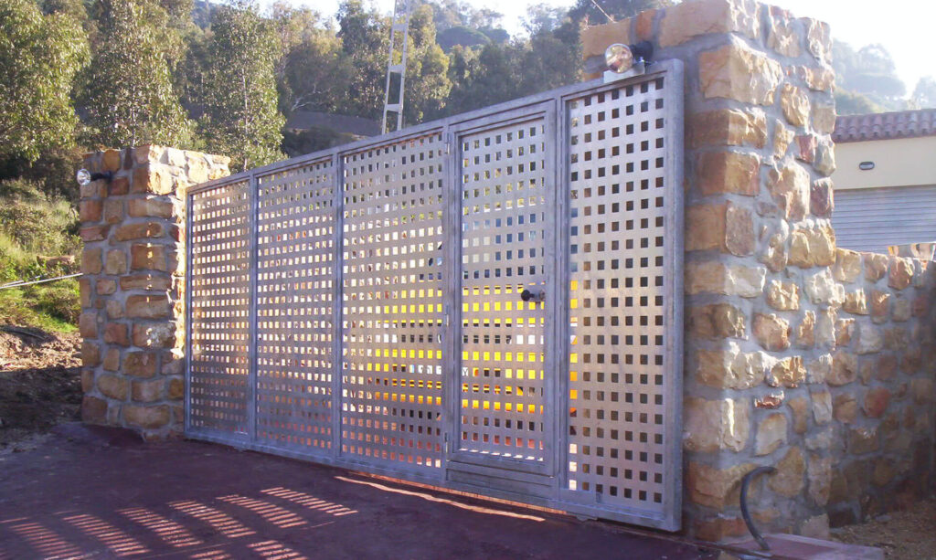 Puerta realizada con paneles metálicos de perforación cuadrada Puerta corredera metálica
